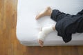 Woman with bandaged foot on bed top view