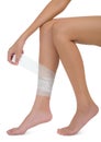 Woman bandaging and first aid her beautiful Healthy long leg in pain area.