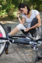 woman bandaging knee after cycling accident