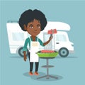 Woman barbecuing meat in front of camper van.