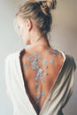 Woman with a bare back with flowers on the skin Royalty Free Stock Photo