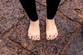 Woman bare feet on wet rocky pavement