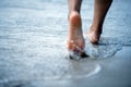 Toe Woman bare foot walking on the summer beach. close up leg of young woman walking along wave of sea water and sand on the beach