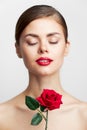Woman with bare shoulders Closed eyes charm rose in hands lipstick Royalty Free Stock Photo