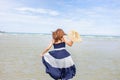 Woman barefoot hold hat and walking on summer along wave of sea water and sand on the beach Royalty Free Stock Photo