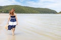 Woman barefoot hold hat and walking on summer along wave of sea water and sand on the beach Royalty Free Stock Photo