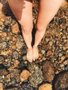 A woman barefoot standing on the stones inside Pemigewasset River