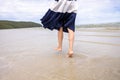 Woman barefoot walking on summer along wave of sea water and sand on the beach Royalty Free Stock Photo