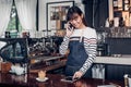 woman barista take order by mobile and tablet,asia female waitress using digital device in coffee shop business at counter bar in