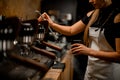 woman barista turns on coffee machine that releases steam to make coffee drink
