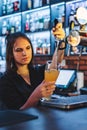 Woman bartender hand at beer tap pouring a draught beer in glass serving in a restaurant Royalty Free Stock Photo