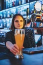 Woman bartender hand at beer tap pouring a draught beer in glass serving in a restaurant Royalty Free Stock Photo