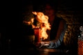 Woman bartender holding glass with cocktail sprinkles on it and masterfully make fire. Royalty Free Stock Photo