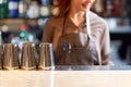 Woman bartender and shakers at bar