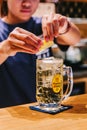 Woman bartender squeezing a slice of lemon over Japanese Whiskey Highball