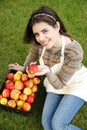 Woman with basket apples against green grass