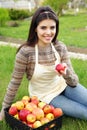 Woman with basket apples against green grass