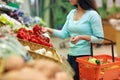 Woman with basket buying peppers at grocery store Royalty Free Stock Photo