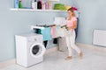 Woman With Basket Of Clothes In Utility Room Royalty Free Stock Photo