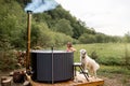 Woman bathing in hot tube, while resting with her dog on nature Royalty Free Stock Photo