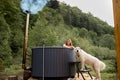 Woman bathing in hot tube, while resting with her dog on nature Royalty Free Stock Photo