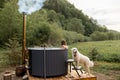 Woman bathing in hot tube, while resting with her dog on nature Royalty Free Stock Photo