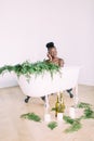 Woman bathing in a tub full of foam. Beautiful african american bride in decorated bath