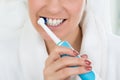 Woman In Bathrobe Brushing Teeth With Electric Toothbrush Royalty Free Stock Photo