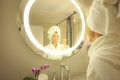 Woman in bathrobe cleaning her teeth