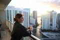 Woman in bathrobe drinking Her morning coffee or tea on a downtown balcony. beautiful sunrise in downtown Miami. Woman enjoying Mi Royalty Free Stock Photo