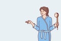 Woman in bathrobe holding shower brush in hand going to take bath and do self bodycare Royalty Free Stock Photo
