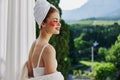 Woman in a bathrobe in a white robe the balcony overlooks the mountains looking on the view