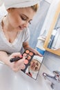 Woman in bathroom applying contour bronzer on brush