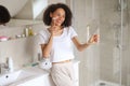 A woman in the bathroom brushing teeth, looking at herself in mirror Royalty Free Stock Photo