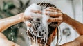 Woman in bathroom using shampoo and shower to wash her hair for optimal cleanliness