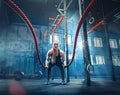 Woman with battle rope battle ropes exercise in the fitness gym. Royalty Free Stock Photo