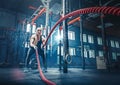 Woman with battle rope battle ropes exercise in the fitness gym. Royalty Free Stock Photo