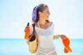 Woman with beach bag, orange flip flops and bottle of sunscreen