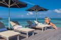 Woman on beach enjoying sunlight on sun loungers Royalty Free Stock Photo