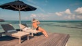 Woman on beach enjoying sunlight on sun loungers Royalty Free Stock Photo