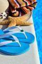 Woman beach hat, bright towel and blue flip-flops Royalty Free Stock Photo