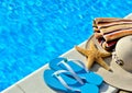 Woman beach hat, bright towel and blue flip-flops. Royalty Free Stock Photo