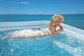 Woman in beach hat enjoying in jacuzzi, swimming pool on Tropical Resort. Exotic Greece Paradise. Travel, Tourism and Vacations C Royalty Free Stock Photo
