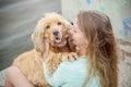 A woman on the beach with her Chocker Spaniel in front of a graffiti wall.