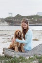 A woman on the beach with her Chocker Spaniel