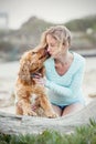 A woman on the beach with her Chocker Spaniel