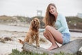 A woman on the beach with her Chocker Spaniel