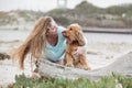 A woman on the beach with her Chocker Spaniel