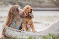 A woman on the beach with her Chocker Spaniel