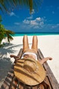 Woman at beach lying on chaise lounge